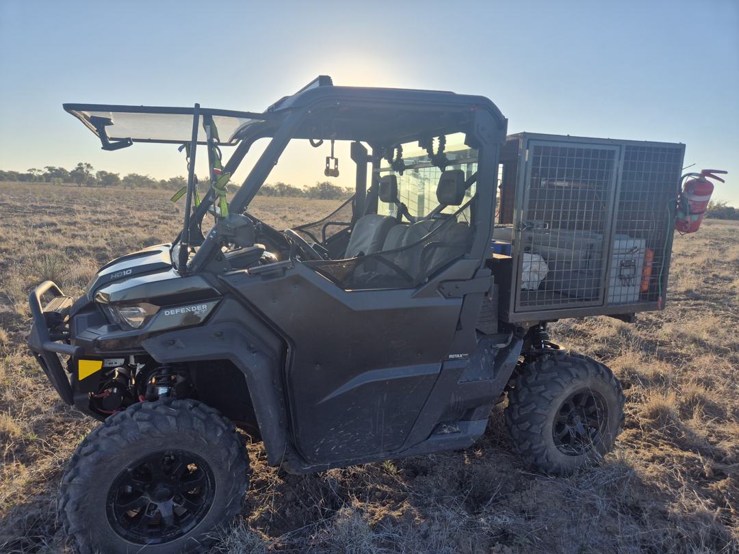Purpose-built side-by-side ground control vehicle fitted with a rear cage, parked in open paddock country